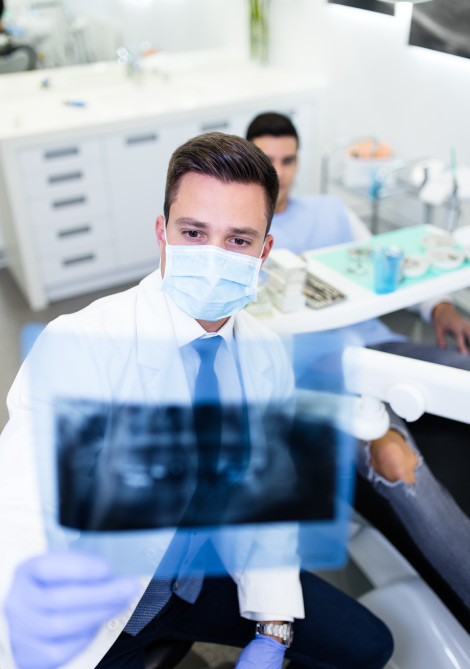 dentist looking at teeth x-rays
