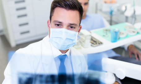 dentist looking at teeth x-rays