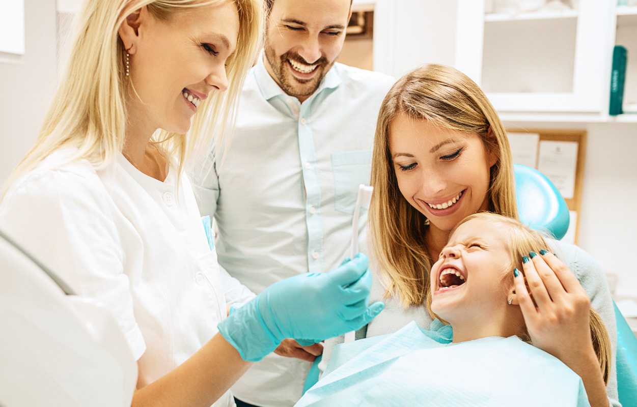 parents with child at dentist