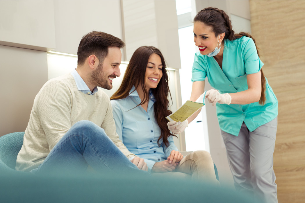 dentist showing couple brochure