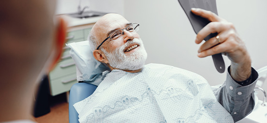 man smiling looking in mirror at dentist