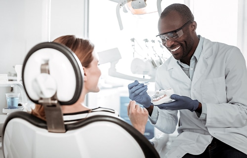 dentist showing patient a tooth model