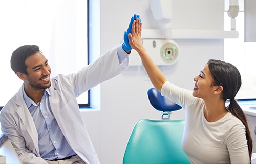 dentist and patient sharing a high five