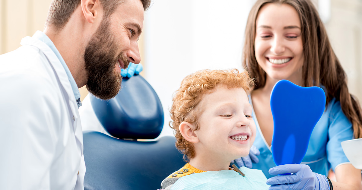 Child at dental appointment with professionals.