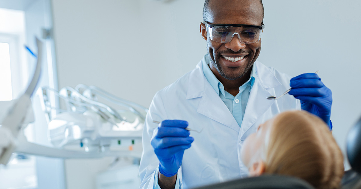 Dentist smiling and patient looking up
